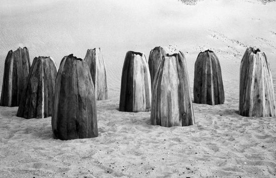 Untitled (Nine Cones) — Ursula von Rydingsvard, 1976 Cedar 1.07 x 4.57 x 3.96 m / 3 ft 6 in x 15 ft  Installation view, Battery Park City Landfill, New York NY, 1977 Courtesy Hauser & Wirth and Galerie Lelong, New York